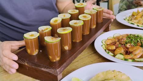 shrimp and seafood buffet served on wooden table during meeting, juice shrimp shots in foreground
