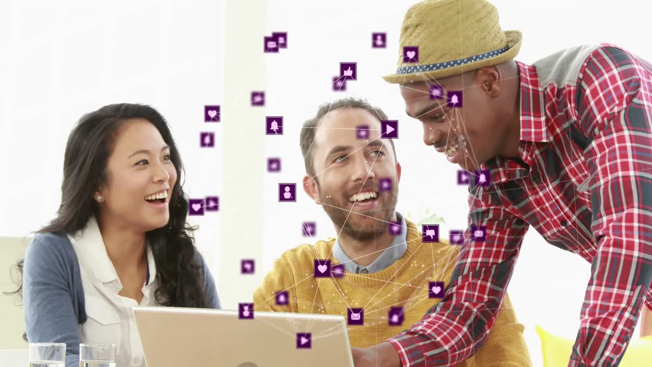 globo de iconos digitales contra un grupo de diversos colegas de oficina que usan portátiles juntos en la oficina