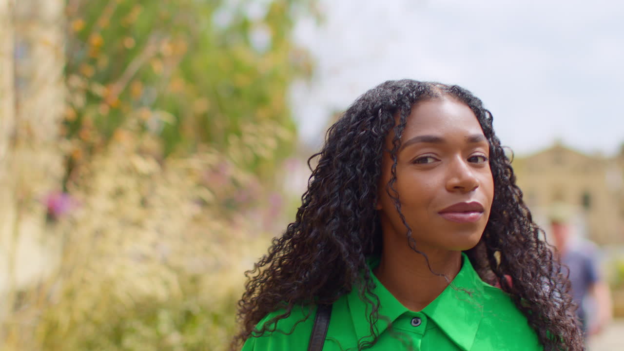 영국 옥스퍼드에서 휴가를 보내고 있는 여성 관광객이 브로드 스트리트를 따라 고 있는 모습