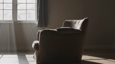 sunlight streams into a quiet room with an armchair