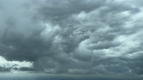 dramatic sky while flying near the botton of a huge storm cloud cumuloninbus