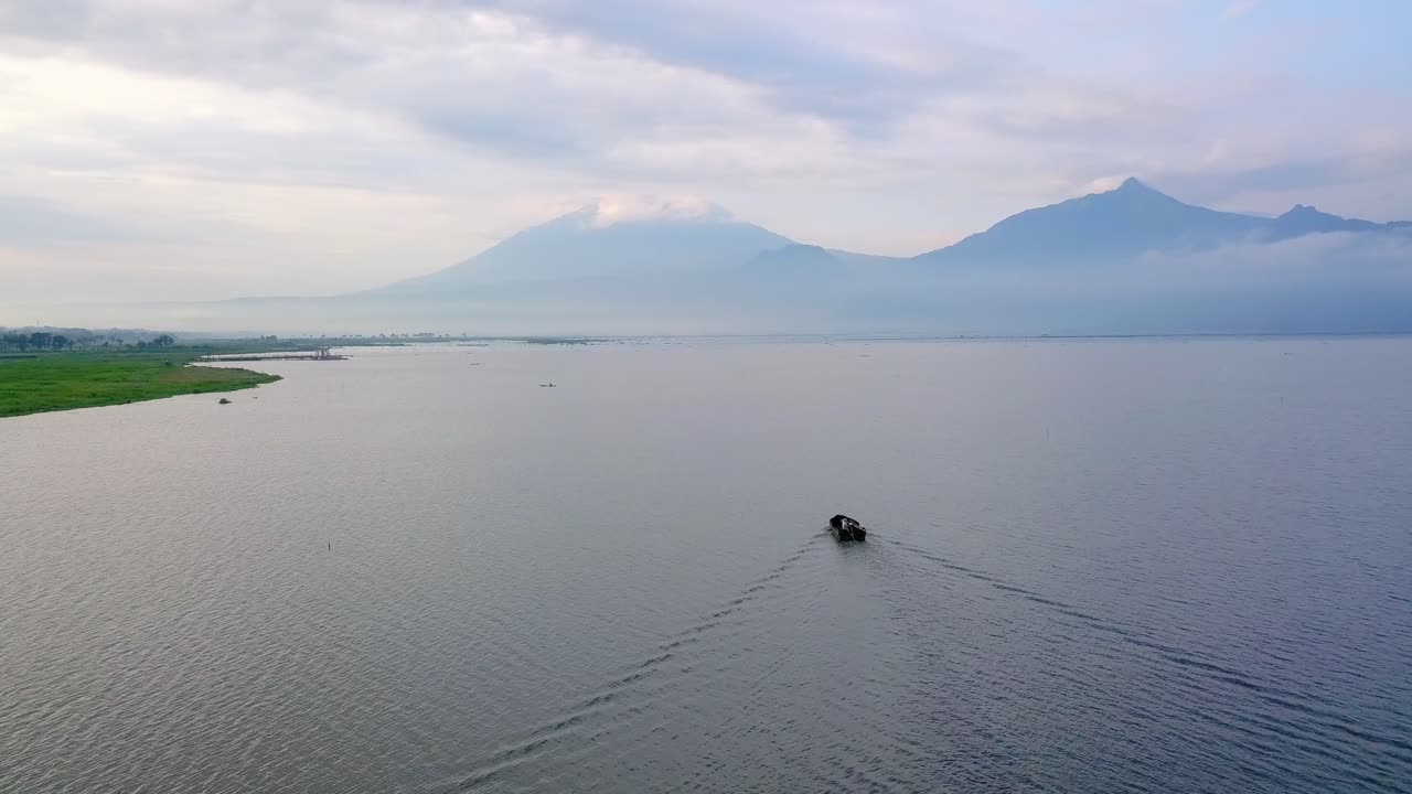 vista aérea de un solo barco que cruza el lago en un ambiente volcánico tropical de indonesia