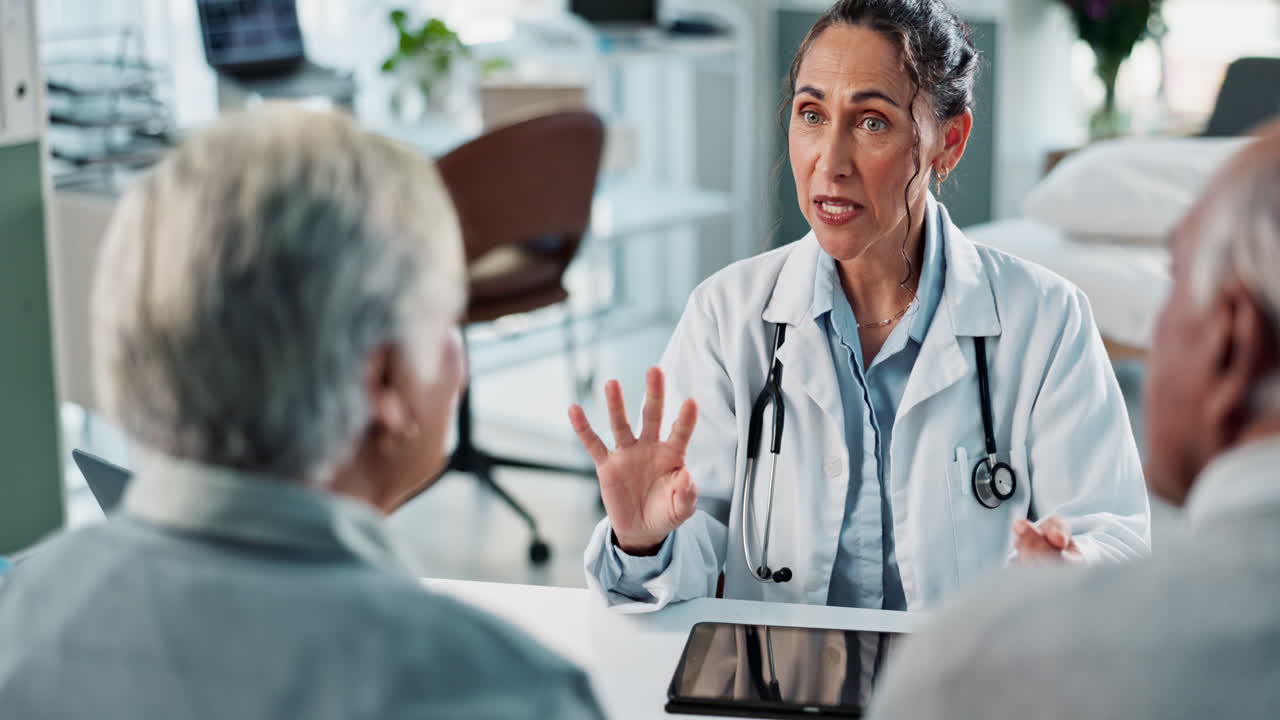 un médico que consulta con una pareja de ancianos en una clínica