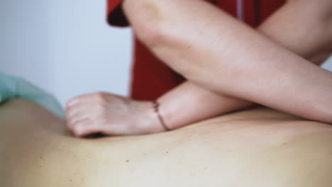 doctor does traditional massage of young female patient back