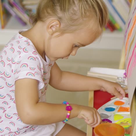 linda niña mezclando pinturas para su pintura