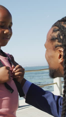 video of happy african american father and son talking by sea