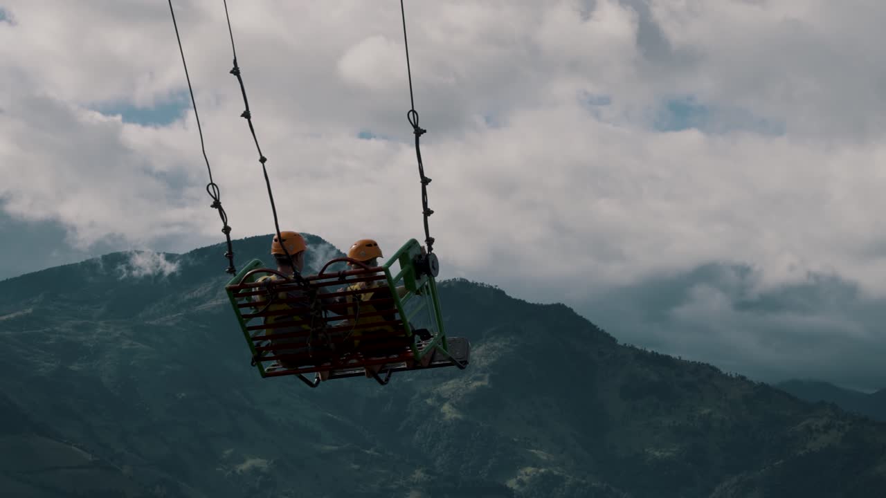 туристы катаются на качелях в конце