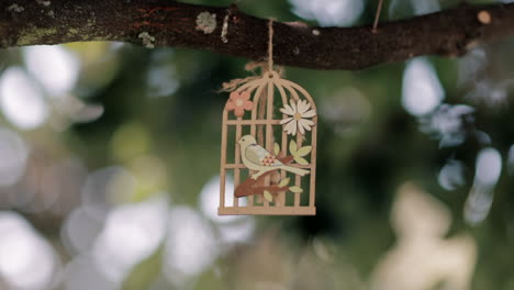 artistic wooden birdcage amidst blurred foliage