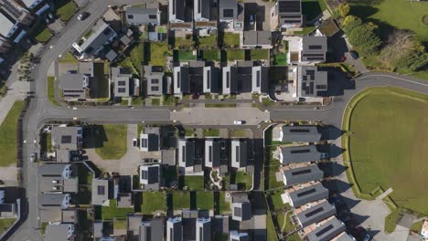 top-down aerial of white new-build block formation with driveways and rooftop solar arrays demonstrating master-planned energy-efficient construction