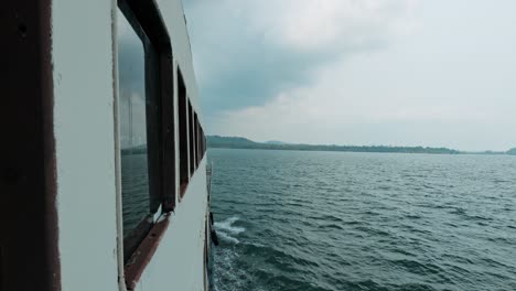 Vista-Desde-La-Ventana-Del-Barco-Con-Las-Olas-Del-Mar-Y-Vista-De-La-Isla-De-Destino