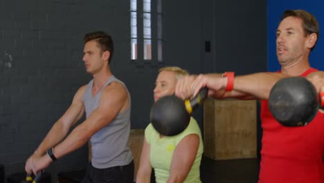 grupo de personas haciendo ejercicio con kettlebell