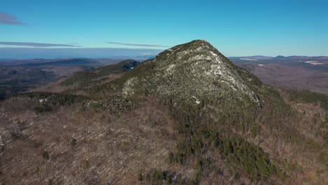 aerial pull back with decent farther from the snow dusted mountain in maine