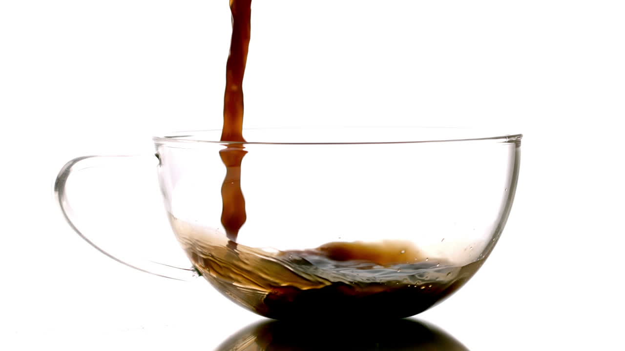 Hot tea pouring into glass cup