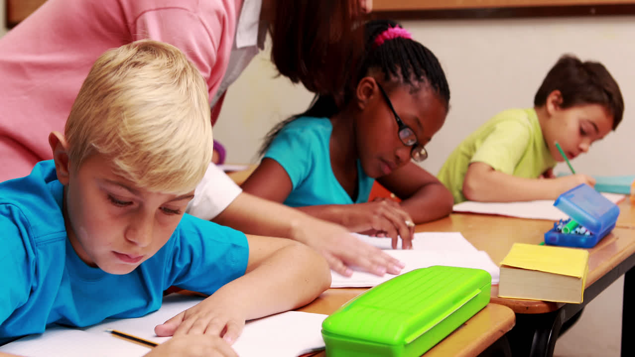 Young teacher helping her pupils