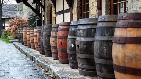 a row of wooden barrels lined up on the side of a building