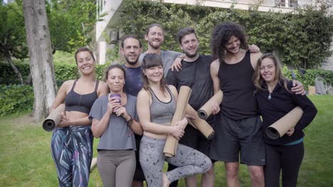 grupo de yoga sonriendo a la cámara al aire libre