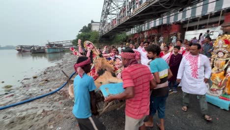men carrying durga idol for immersing into holy ganga river in kolkata, india. durga puja last day.