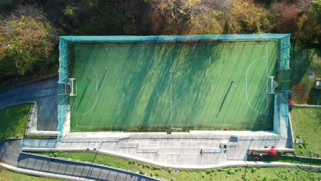 cinematic drone shot of a football field where kids are playing