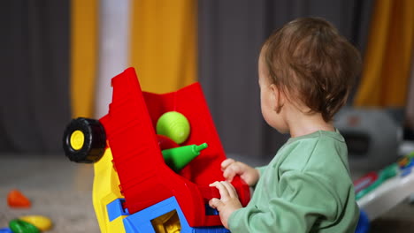 baby playing with colorful toy truck