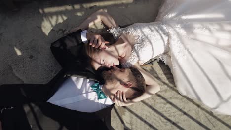 newlyweds. caucasian groom with bride lie on the ground next to each other