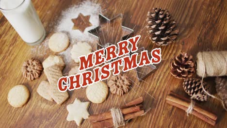 animación de feliz navidad sobre galletas y decoraciones en superficie de madera