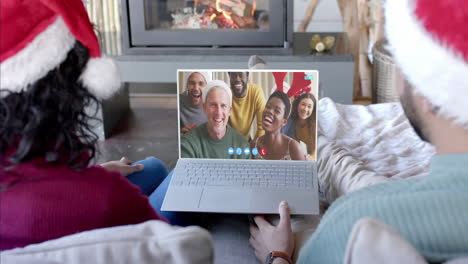 Happy-diverse-couple-and-group-of-friends-having-christmas-laptop-video-call,-slow-motion