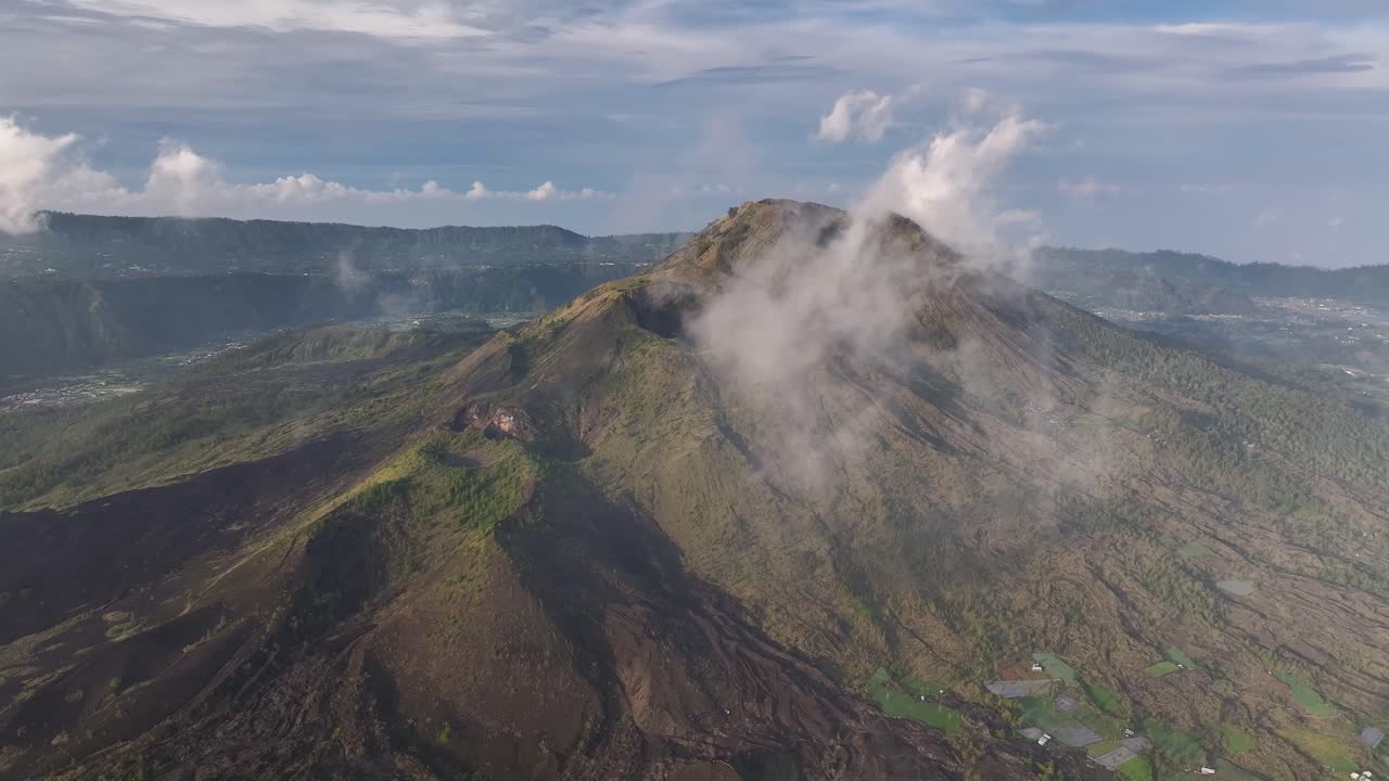 Drone fly to Mount Batur volcano crater through the clouds, dynamic landscape. Bali, Indonesia