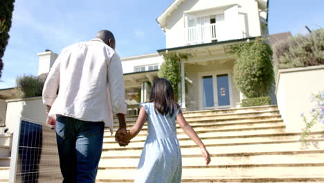 holding hands, father and daughter walking up steps towards house, bonding time