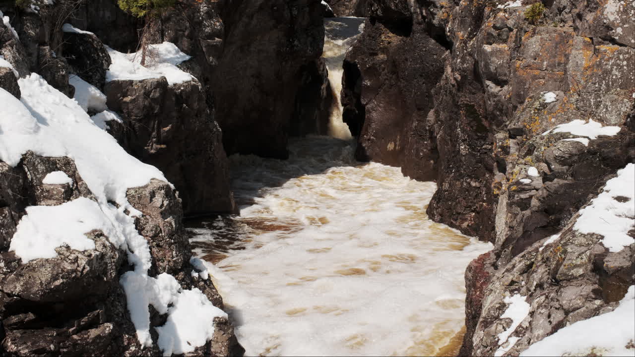 la luz del sol baña un cañón rocoso, derritiendo la nieve y transformándola en un arroyo balbuceante