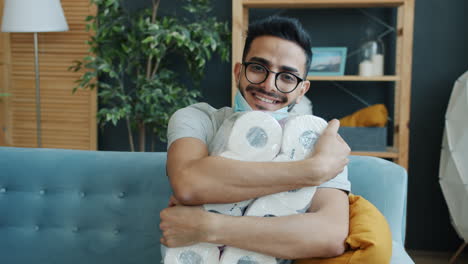 man hugging toilet paper rolls