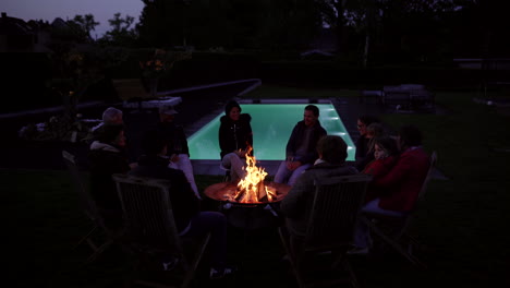 family and friends gathering by the pool at night