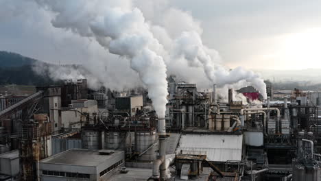 industrial factory emitting thick white smoke, symbolizing pollution and environmental impact