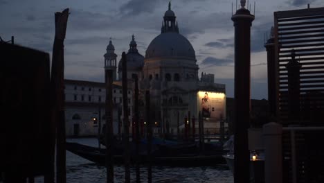 Edificio-Histórico-En-Venecia,-Visto-Desde-Un-Muelle,-Iluminado-Por-La-Luz-Nocturna,-Vista-Nocturna,-Escena-Callejera