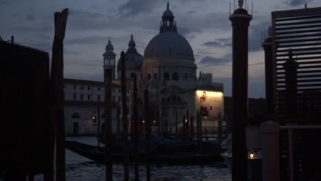 historical building in venice, viewed from a dock, illuminated by the nighttime light, nocturnal view, street scene