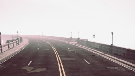 Asphalt-highway-and-mountain-in-deep-fog