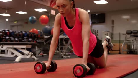 mujer haciendo flexiones en el gimnasio