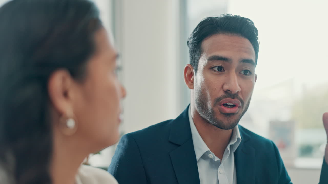 Businessman Talking and Explaining to a Colleague in an Office
