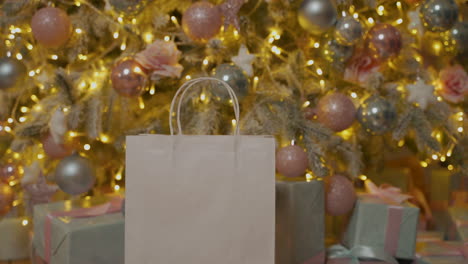 close up of hand taking a christmas gift box from a paper bag with blank space