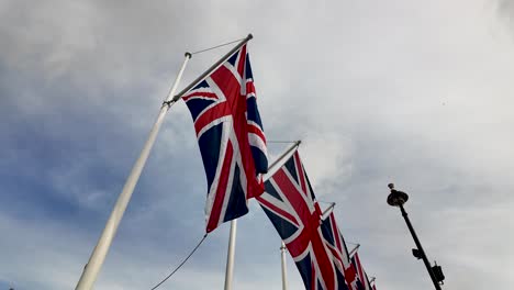 union jack flags waving under a cloudy sky
