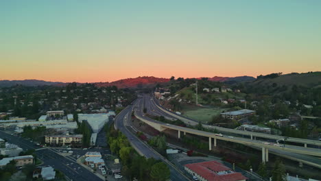 aerial drone shot over downtown walnut creek, with the bart and highway 680 surrounded by houses in california, usa during evening time