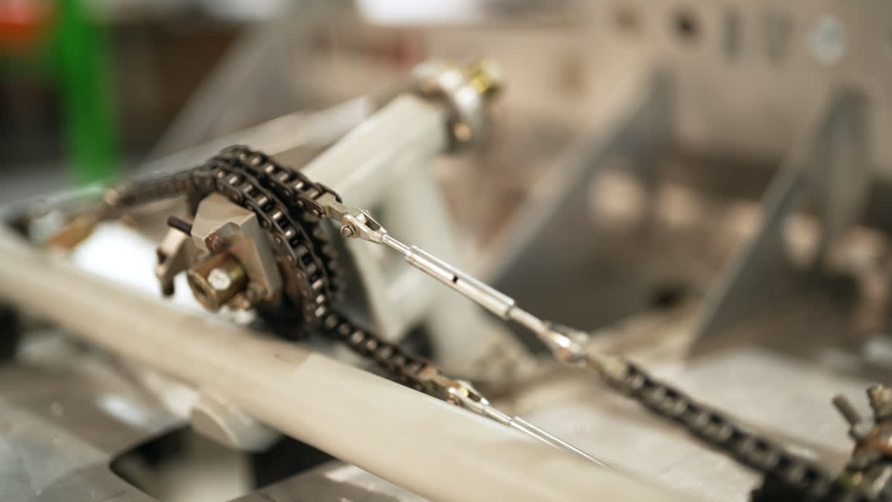 Mechanical chain drive system moving gears and linkages in an industrial assembly process, close up