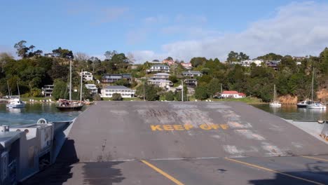 passenger and car ferry boat with ramp up, keep off, during crossing to town of okiato, old russell, bay of islands, new zealand aotearoa