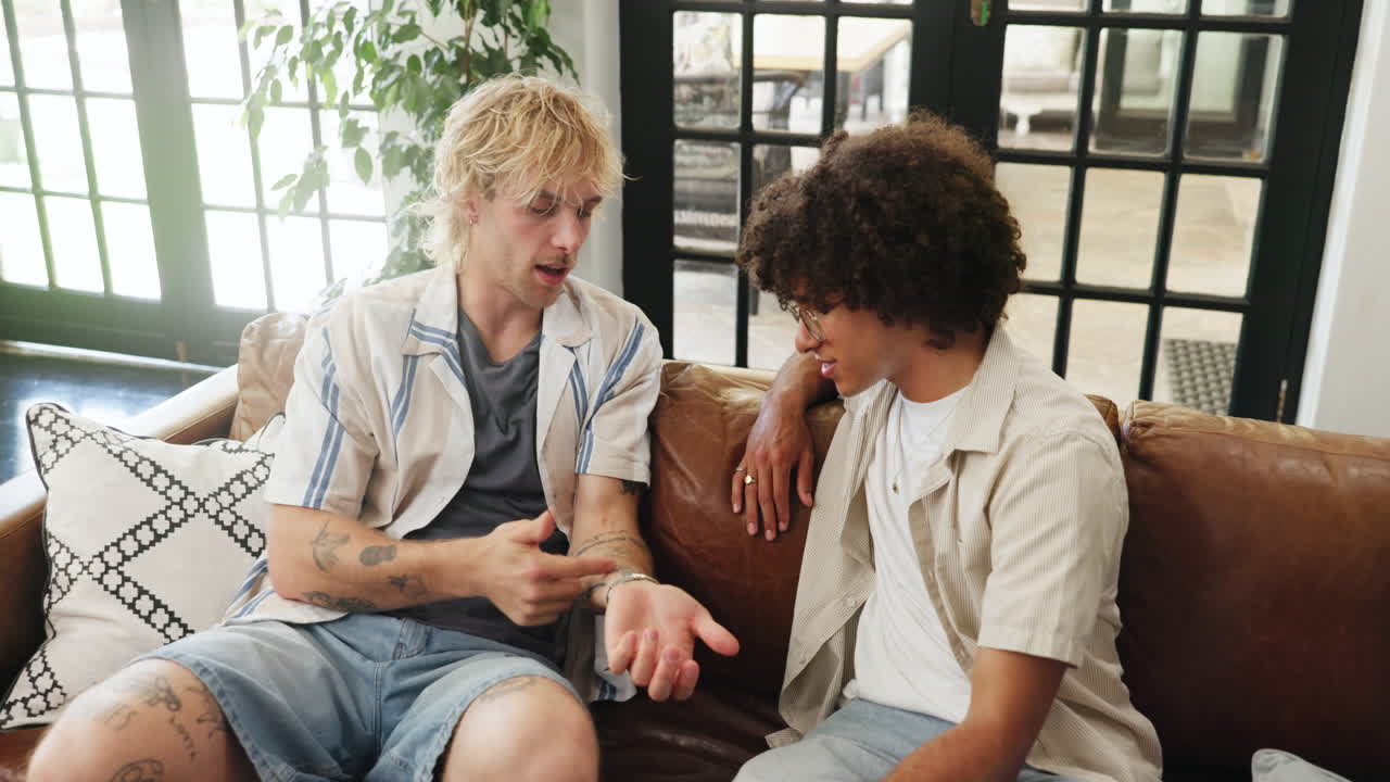 Two Young Men Having a Casual Conversation on a Couch