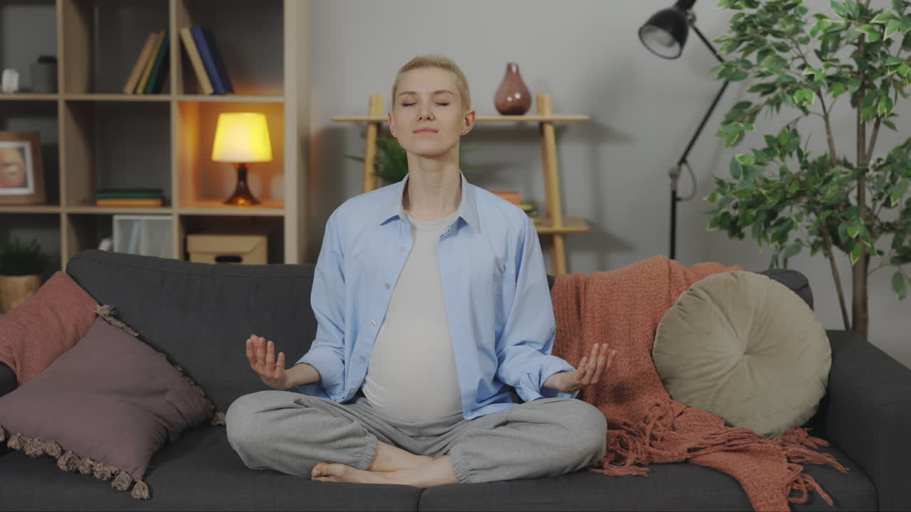 Pregnant Woman Meditating on a Sofa