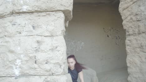 mujer bailando contra un antiguo pilar de roca