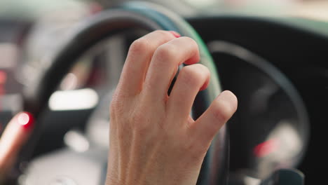 lady driver holds steering wheel tapping fingers expectantly