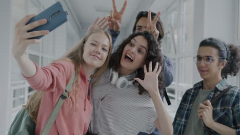 friends taking a selfie in a school corridor