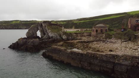 Porth-Wen-aerial-push-in-view-abandoned-Victorian-industrial-brickwork-factory-remains-on-Anglesey-eroded-coastline