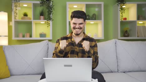 Der-Mann,-Der-Im-Homeoffice-Arbeitet,-War-Begeistert-Von-Dem,-Was-Er-Auf-Dem-Laptop-Sah.