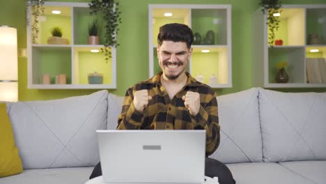 un trabajador de oficina en casa encantado con lo que vio en la computadora portátil.